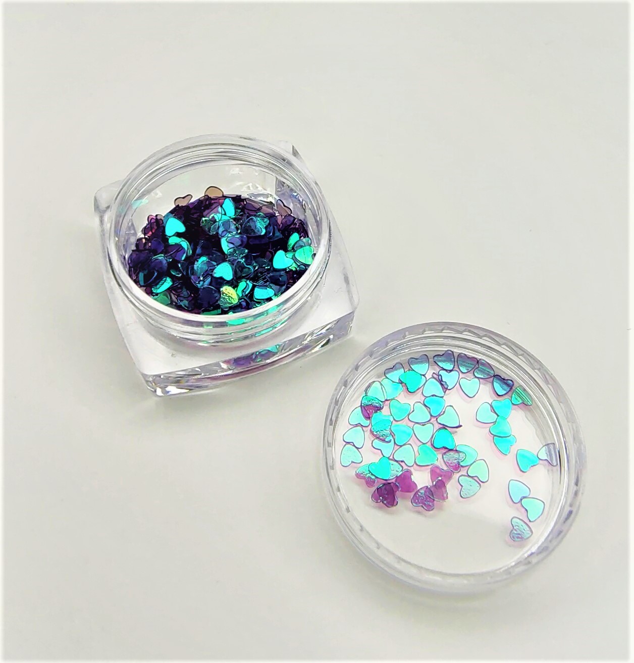 Recipiente com lantejoulas em forma de coração azuis e roxas