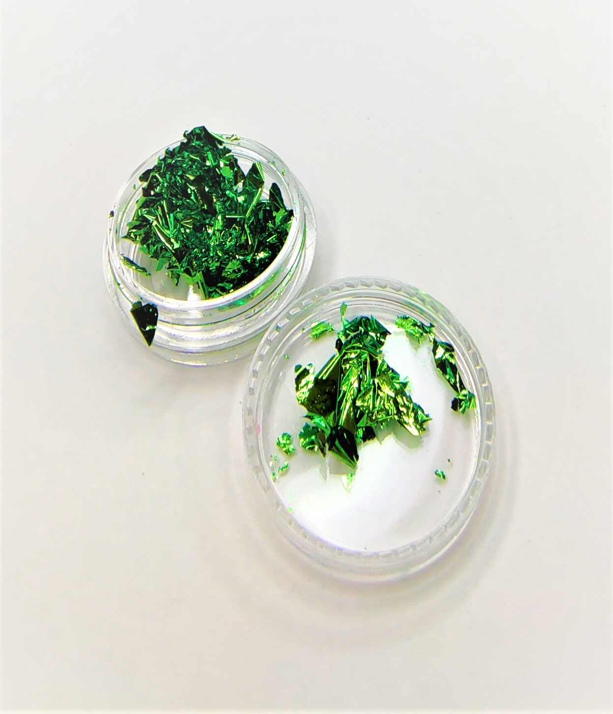 Recipientes transparentes com partículas verdes metálicas.
