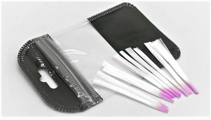 Swabs descartáveis com ponta rosa em suporte preto e transparente