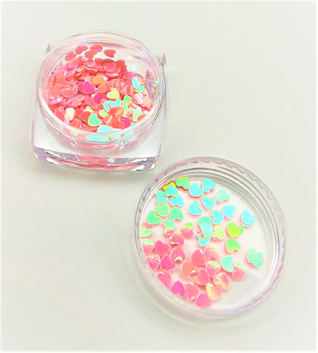 Dois frascos com confetes de coração coloridos
