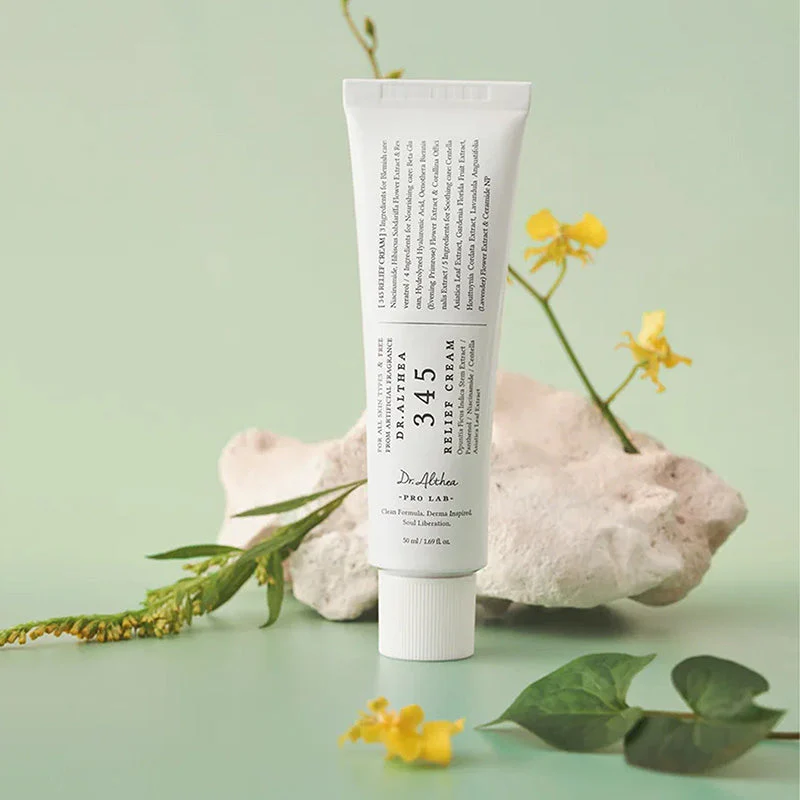 Tubo branco de creme Dalthea 345 Relief Cream com flores amarelas e pedra branca em fundo verde claro
