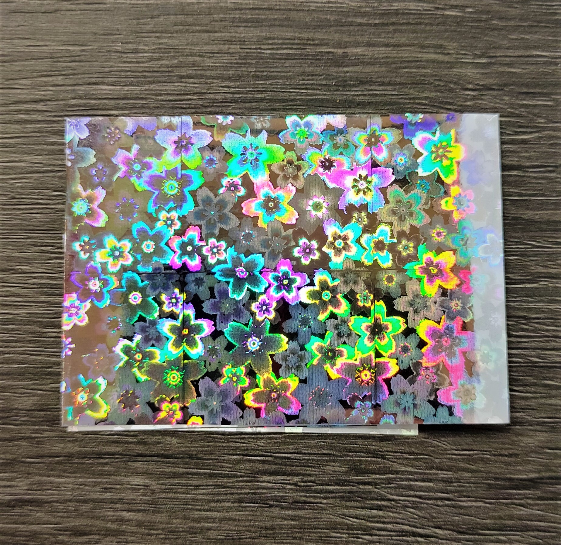 Folha translúcida holográfica com padrão de flores coloridas
