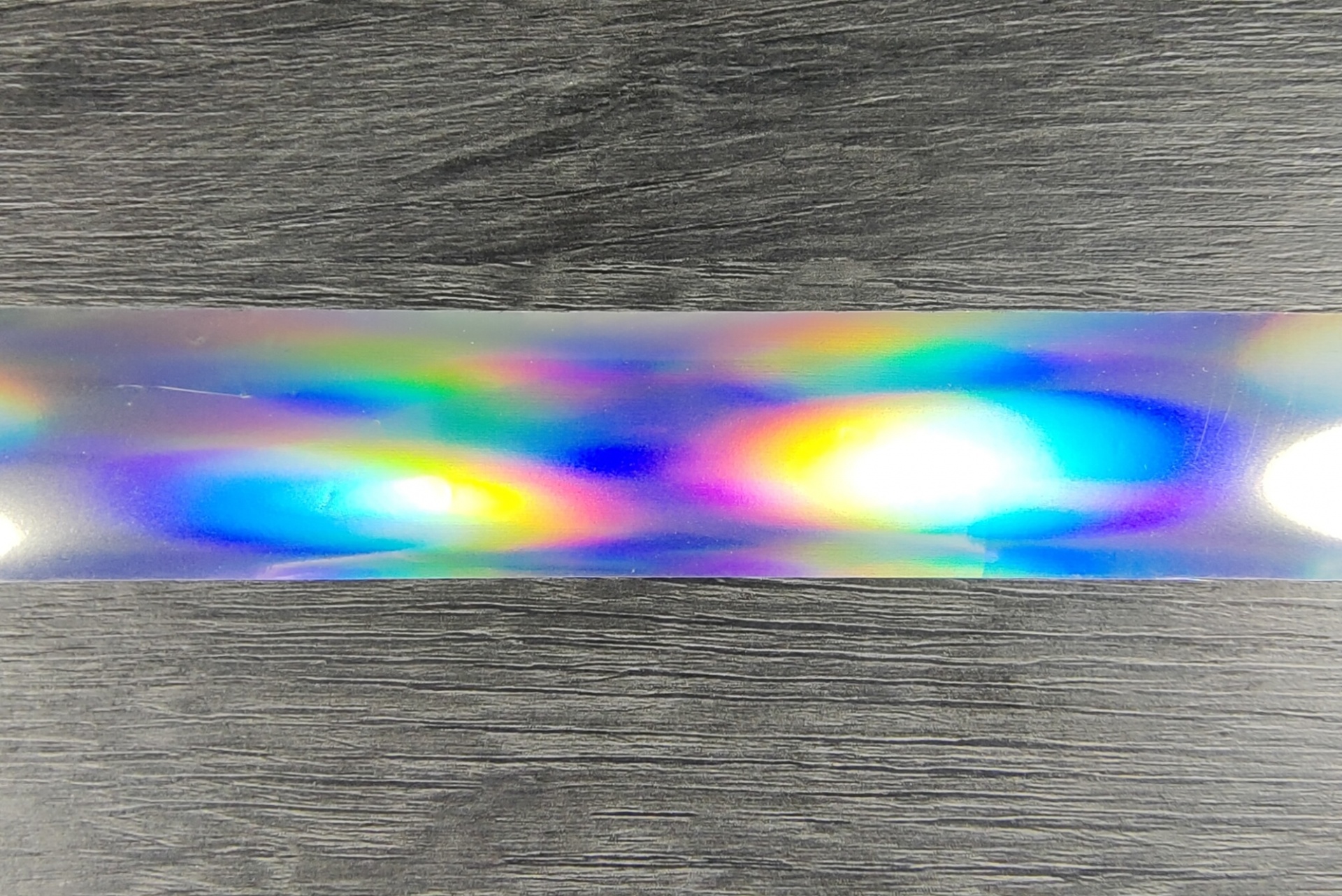 Fita holográfica colorida sobre fundo de madeira