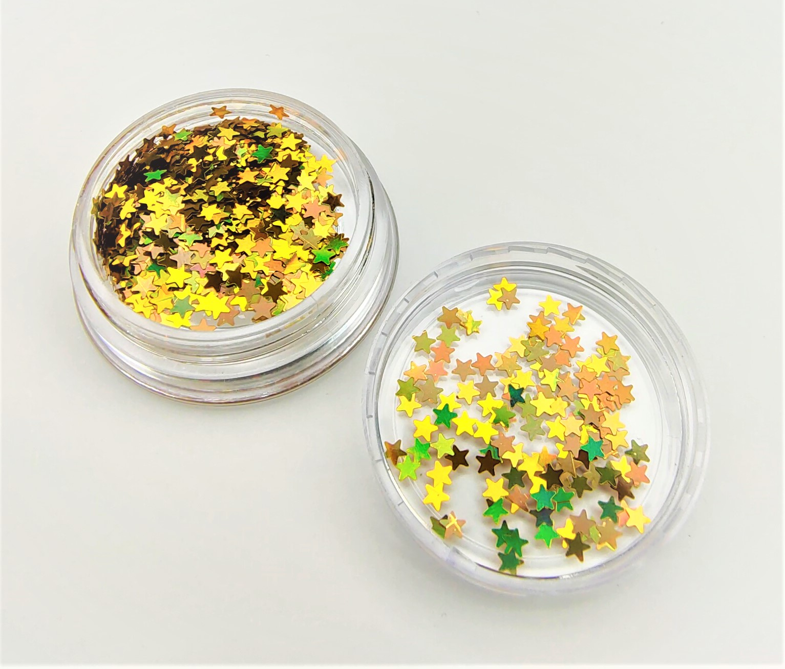 Dois frascos pequenos transparentes com lantejoulas em forma de estrela coloridas