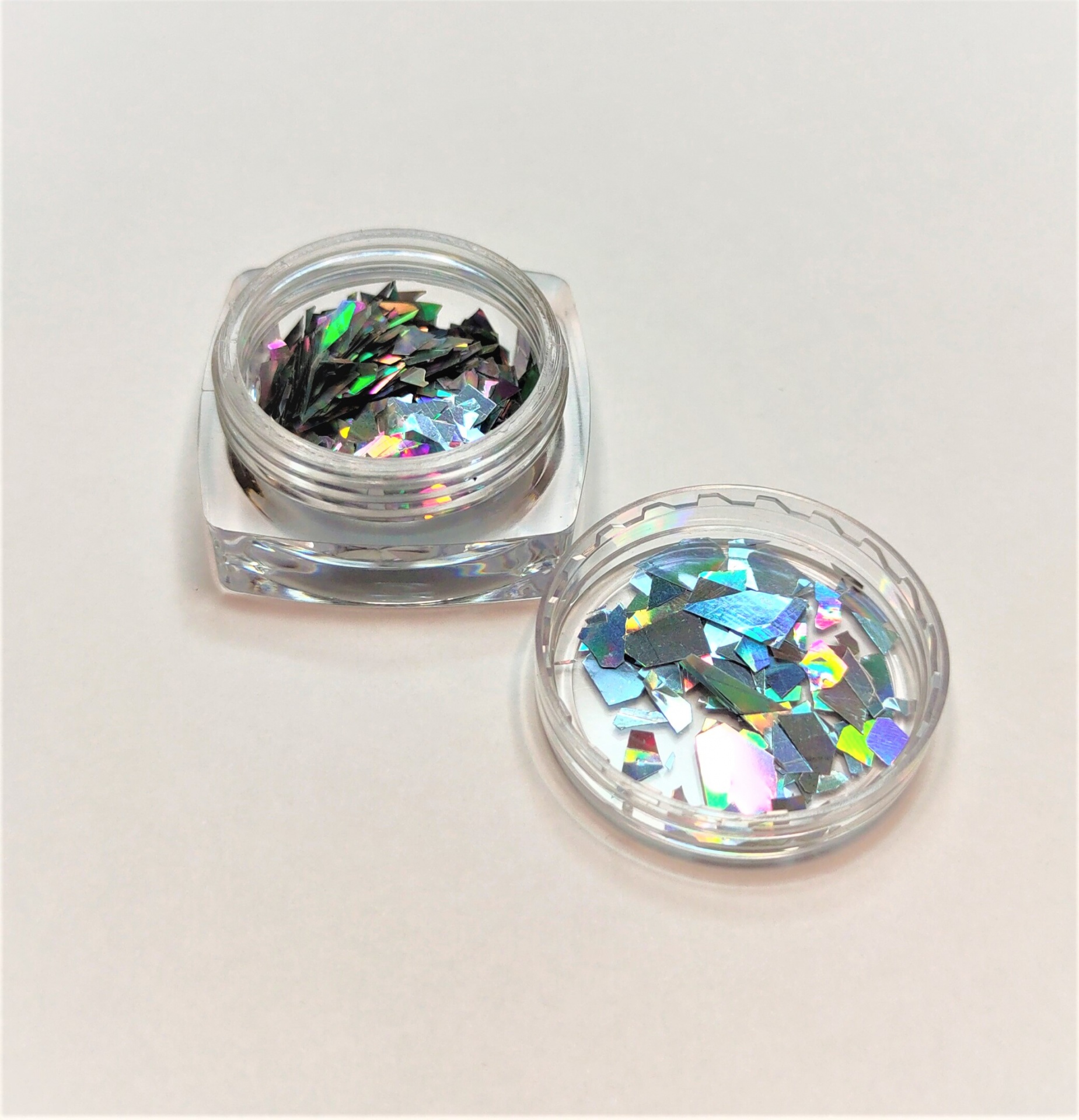 Frasco com glitter holográfico colorido sobre fundo branco