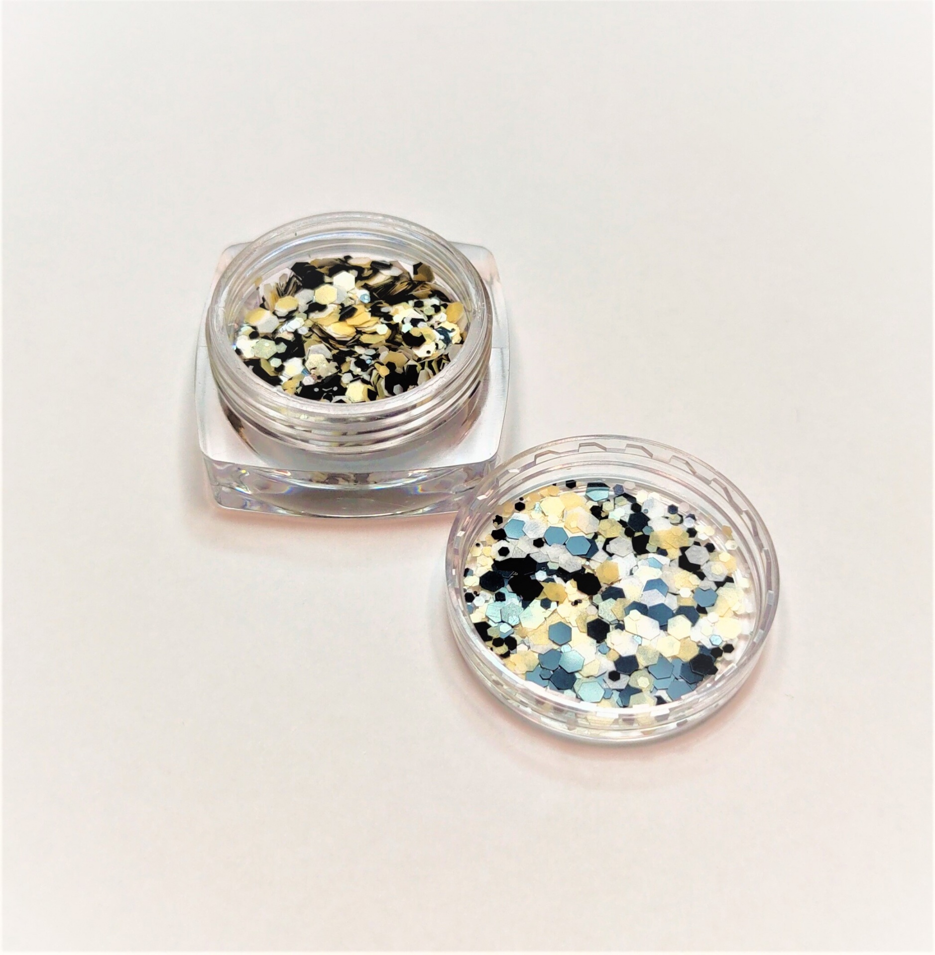 Duas caixas pequenas com glitter colorido em fundo branco