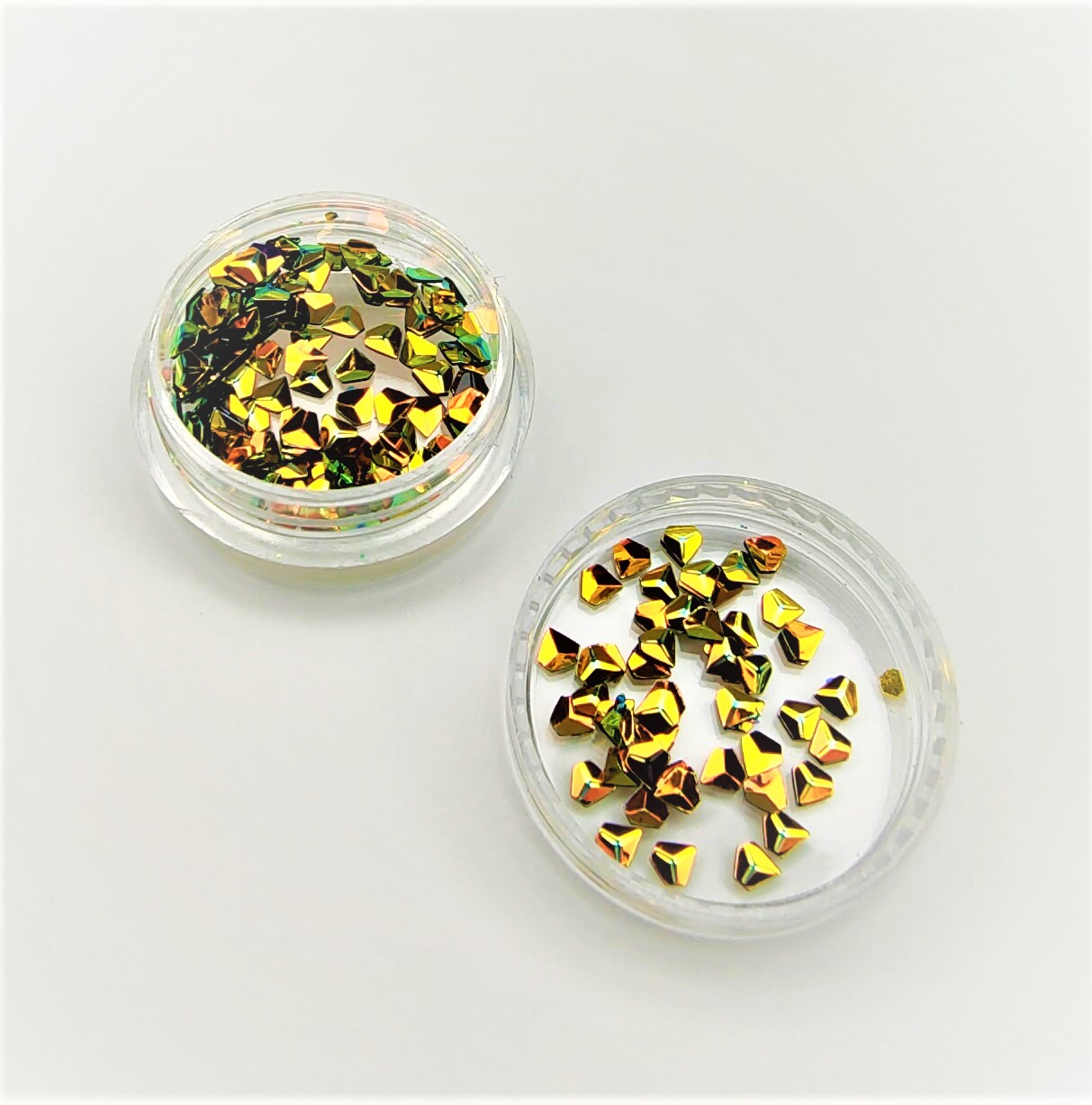 Dois recipientes transparentes com confetes dourados e verdes no interior