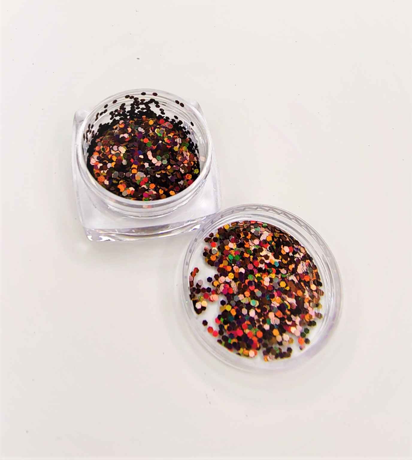 Frasco aberto com glitter colorido em fundo branco