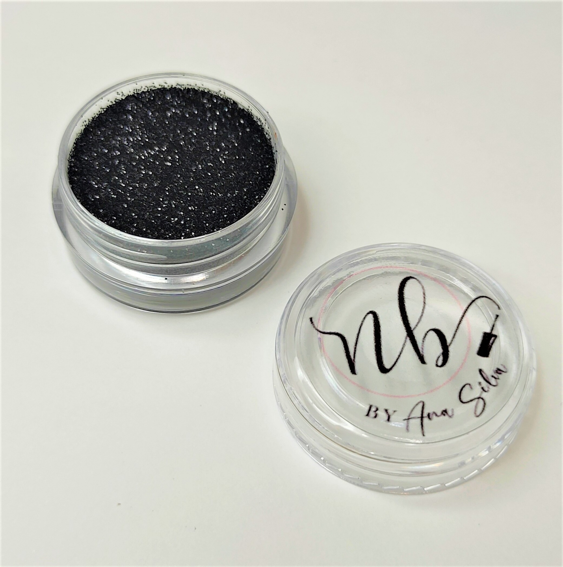 Esponja de maquiagem preta em recipiente transparente com tampa com inscrição nb BY Ana Silva