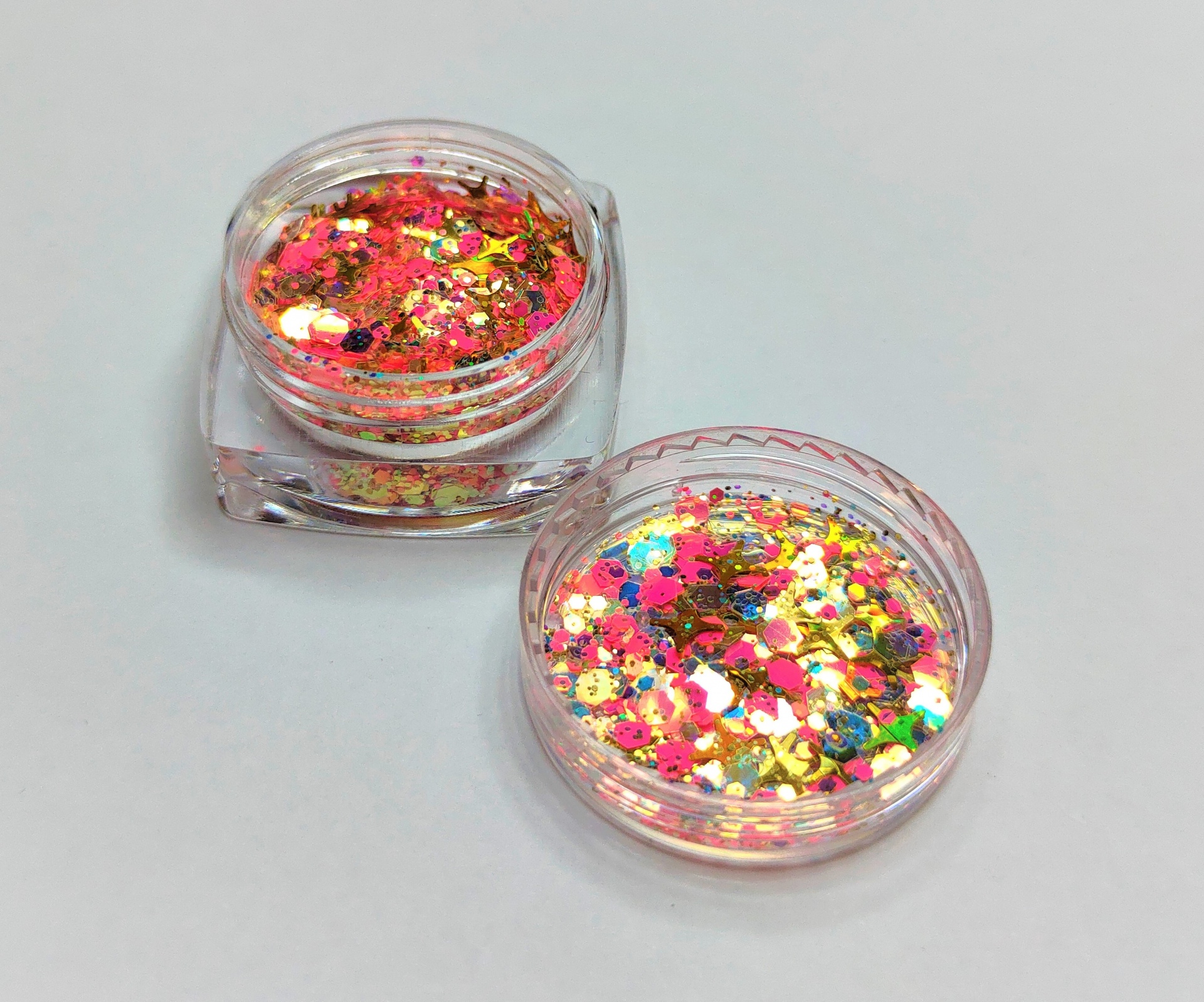 Dois recipientes pequenos com glitter colorido em plástico transparente