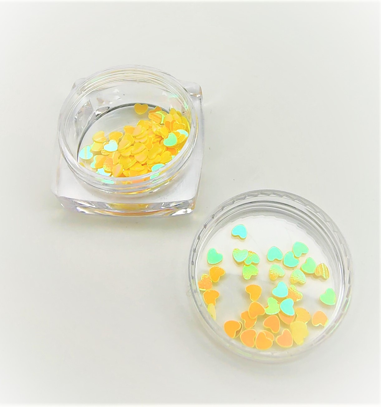 Frascos transparentes com confetes de coração amarelos e verdes