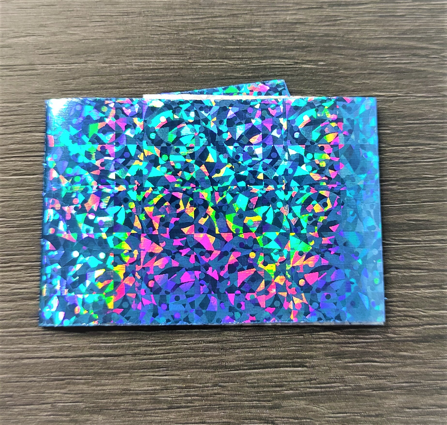Carteira holográfica colorida sobre madeira escura