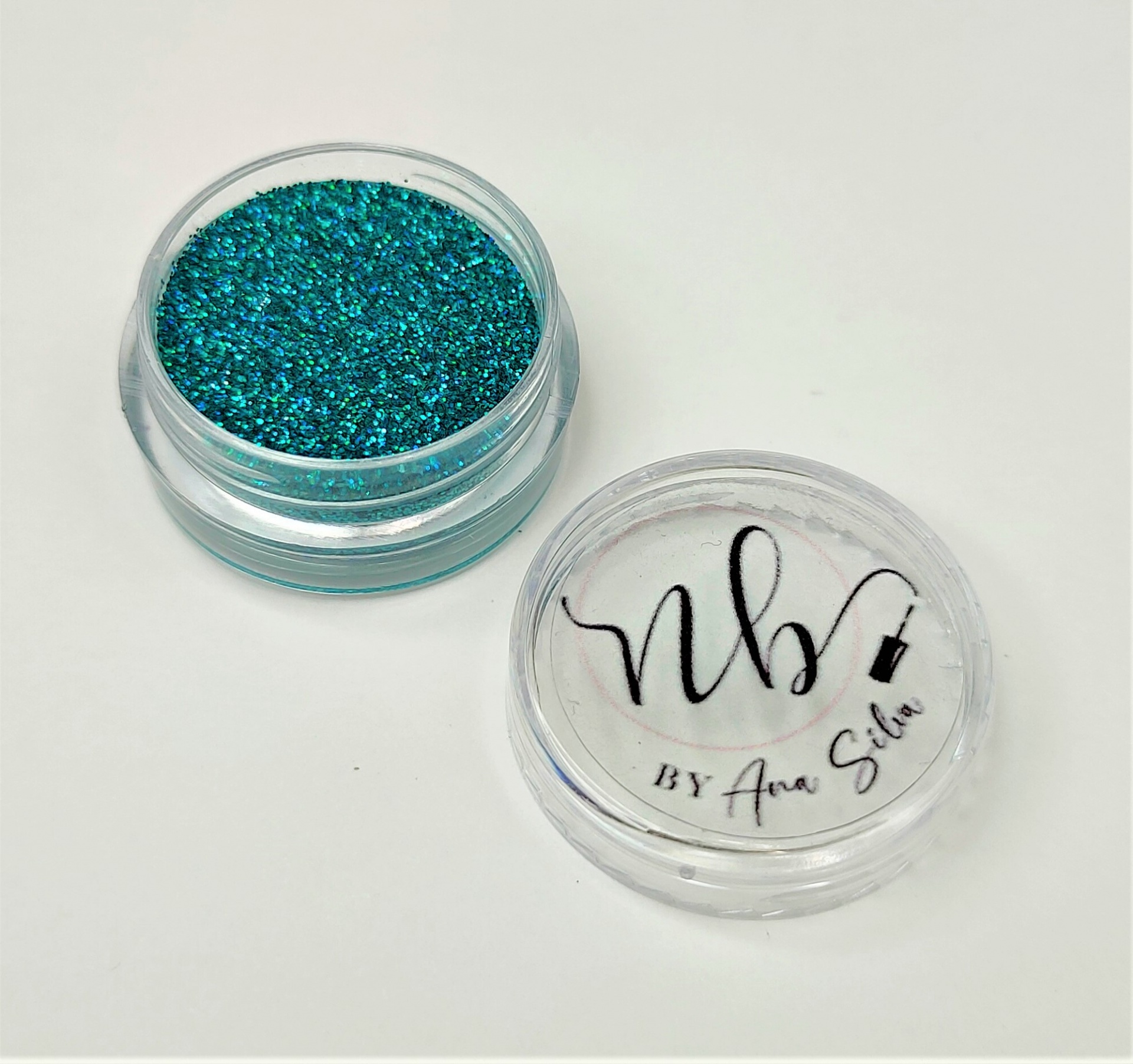 Recipiente transparente com glitter azul-esverdeado e tampa com etiqueta nb! BY Ana Sílvia