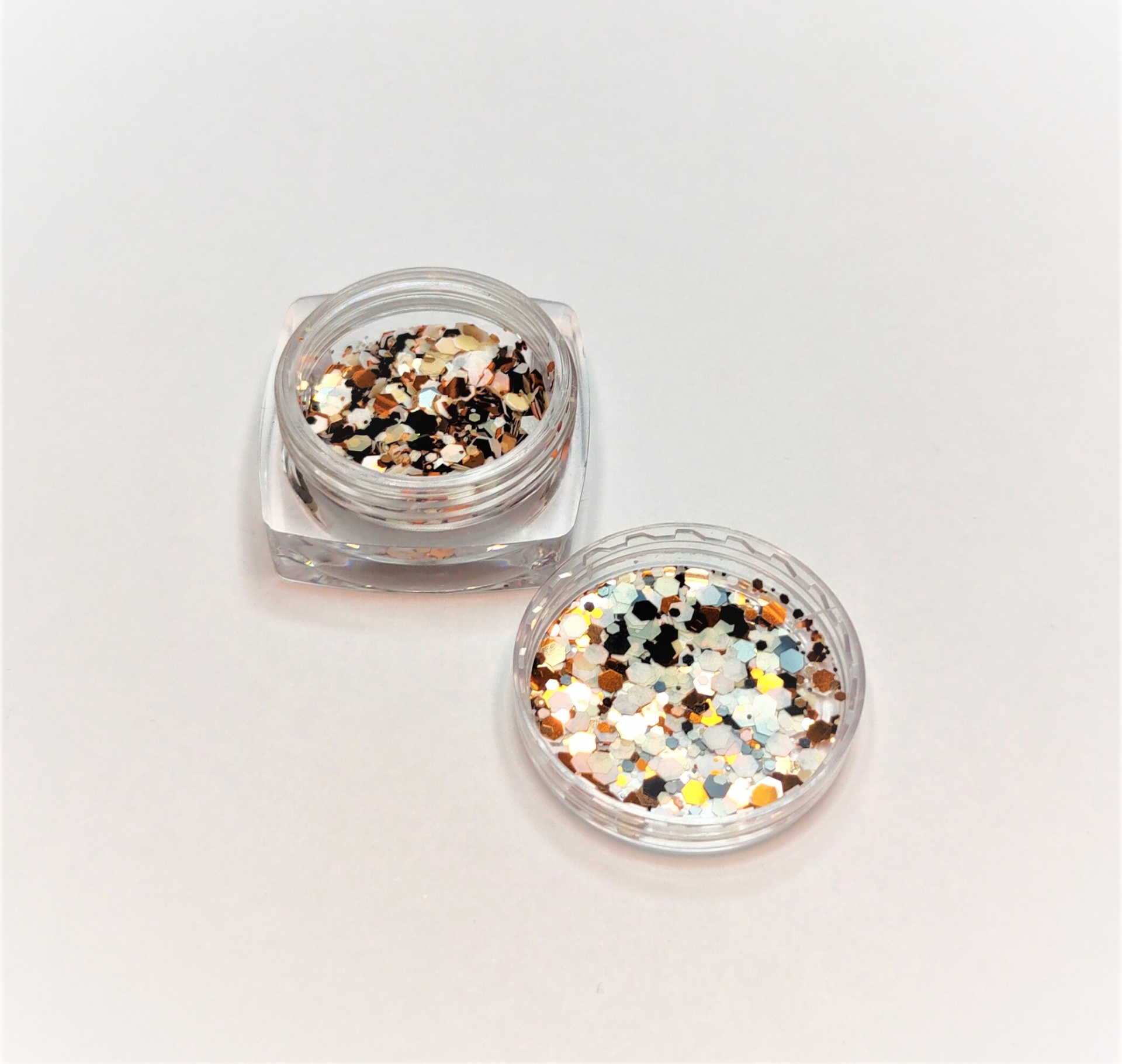 Pequenos frascos transparentes com glitter metálico colorido