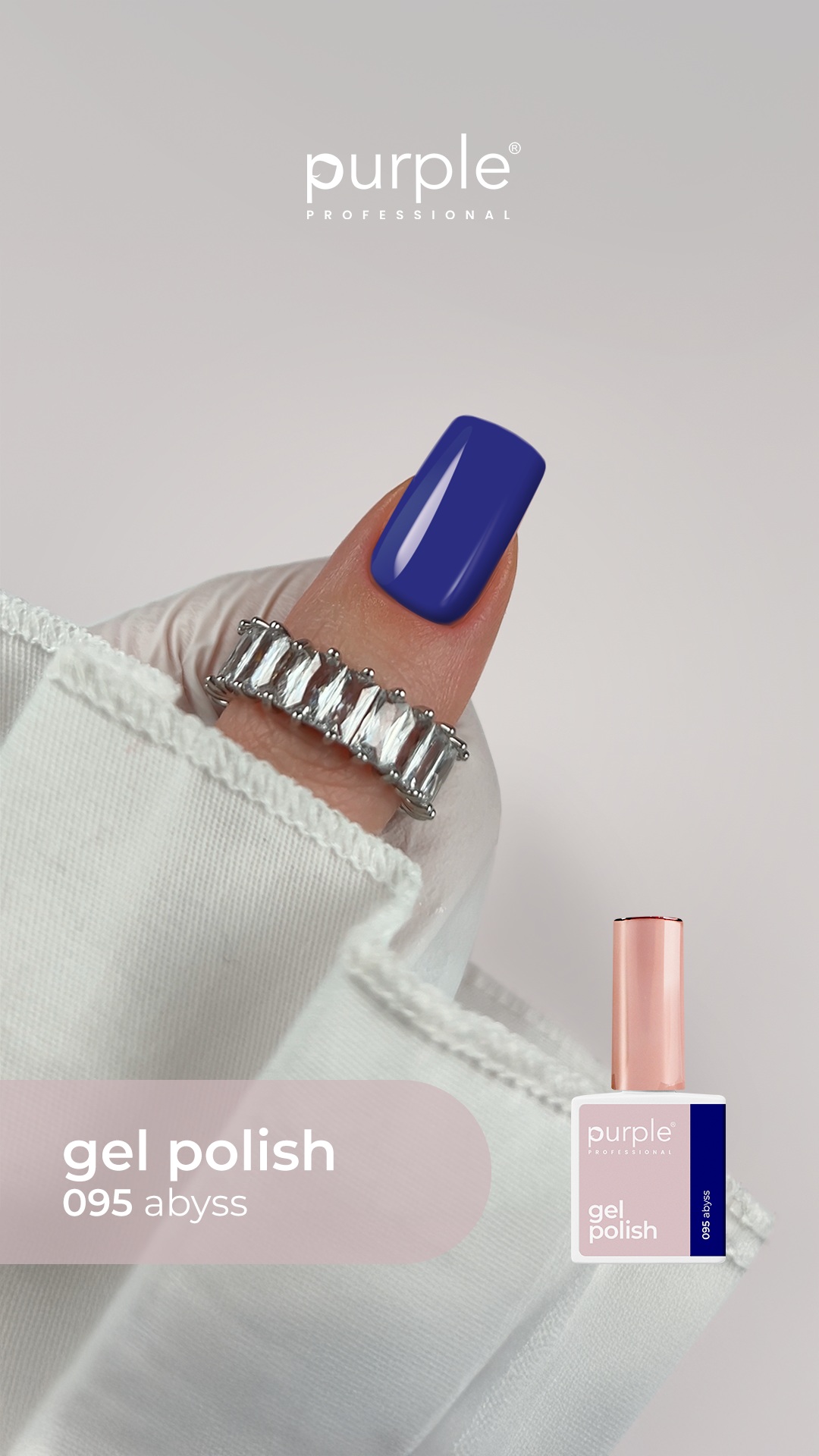 Unha pintada com verniz gel azul escuro brilhante 095 abyss da Purple Professional, com anel prateado e manga branca.