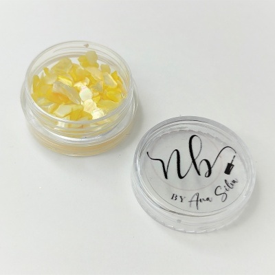 Frasco transparente com pequenos pedaços amarelos e tampa com texto nb by Ana Silva