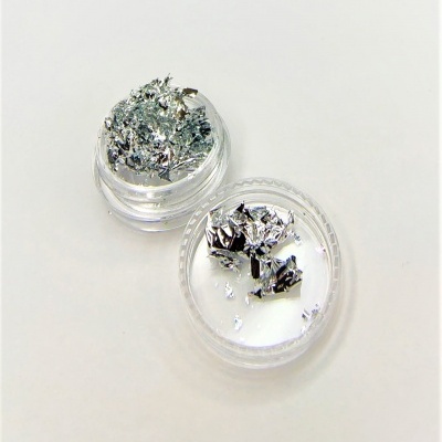 Folhas metálicas prateadas em recipientes transparentes