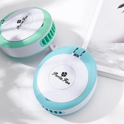 Dois purificadores de ar portáteis redondos verde e azul sobre superfície branca