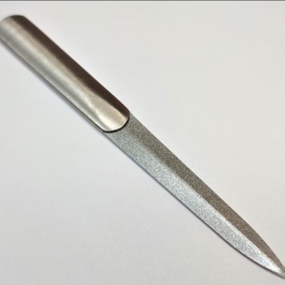 Lima para unhas em metal com superfície texturizada e fundo branco