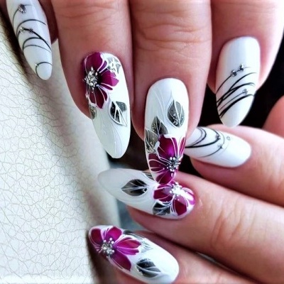 Unhas decoradas com flores roxas e folhas cinzentas sobre fundo branco