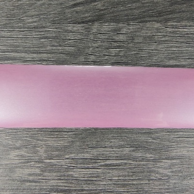 Faixa de tecido rosa claro sobre superfície de madeira escura