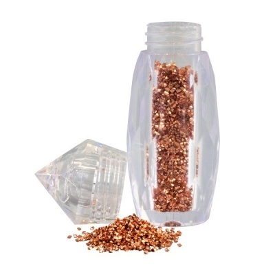 Frasco transparente com granulado castanho dourado derramado