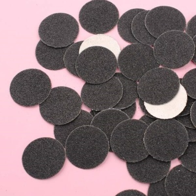 Discos abrasivos redondos pretos e brancos sobre fundo rosa