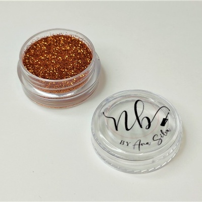 Frasco de glitter dourado com tampa transparente e texto NBV BY Ana Silva