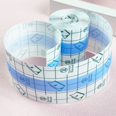 Rolo de fita adesiva transparente com padrões e texto, sobre superfície rosa