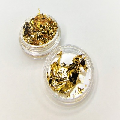 Folhas douradas finas em embalagens circulares transparentes sobre fundo branco