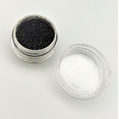 Pote pequeno com produto preto brilhante e tampa transparente ao lado
