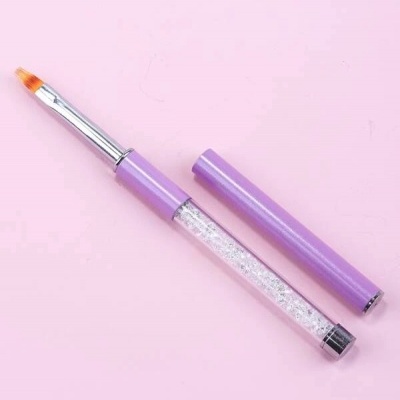 Pincel de maquilhagem lilás com cabo transparente e brilhantes sobre fundo rosa