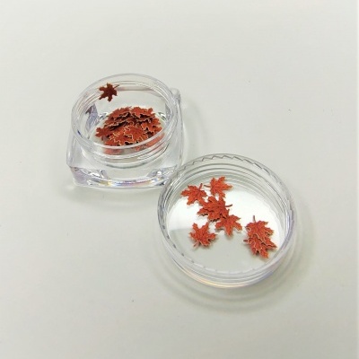 Frascos transparentes com folhas vermelhas decorativas em forma de bordo sobre fundo branco