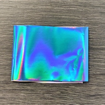 Papel holográfico colorido numa superfície de madeira escura