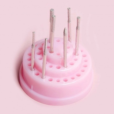 Ferramentas de unhas em base rosa em fundo rosa