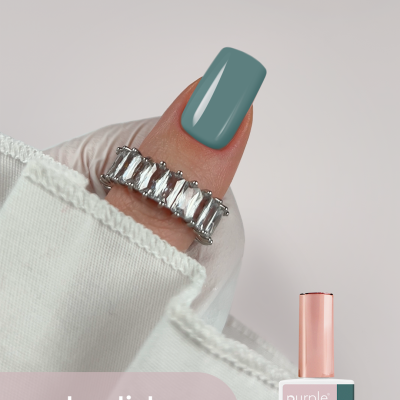 Verniz gel para unhas purple professional cor 093 greenk com unha pintada a verde acinzentado e anel prateado com pedras.