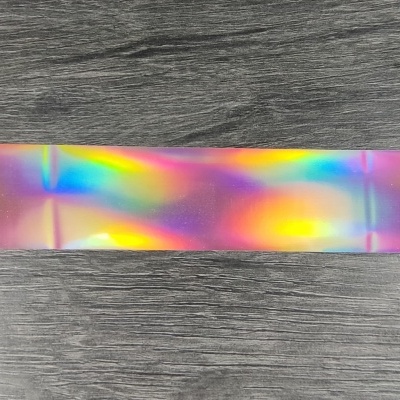 Fita iridescente colorida sobre mesa de madeira cinzenta