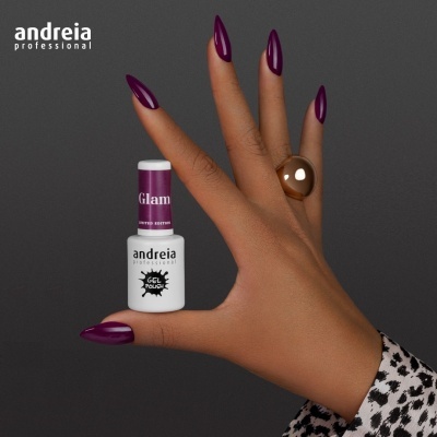 Mão com unhas roxas segurando verniz de unhas da marca Andreia Professional
