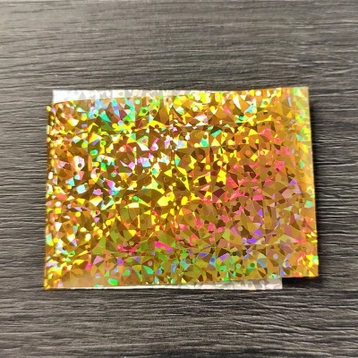 Cartolina holográfica dourada sobre superfície de madeira escura