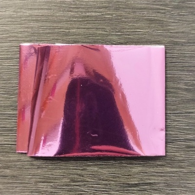Folha metálica rosa brilhante sobre madeira