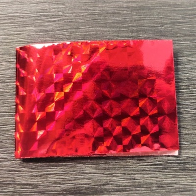 amostra holográfica vermelha brilhante sobre mesa de madeira cinzenta