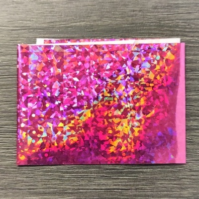 Pacote holográfico colorido sobre superfície de madeira cinzenta