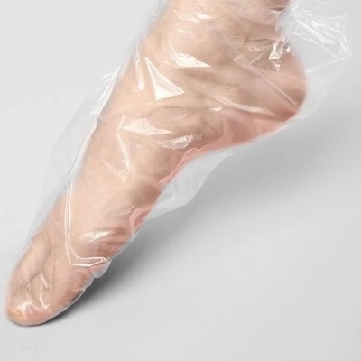Pé coberto por proteção plástica transparente sobre fundo cinza