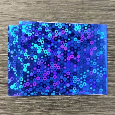 Lenço azul holográfico com padrão de círculos sobre madeira