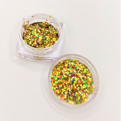 Dois frascos transparentes com purpurina dourada holográfica sobre fundo branco