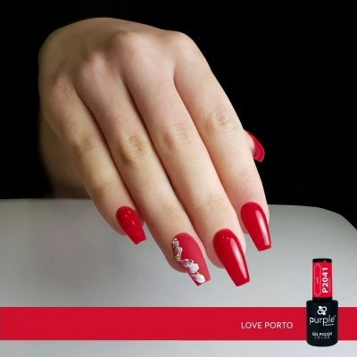 Mão com unhas vermelhas e uma flor decorativa, frasco de verniz gel 'purple' P2041