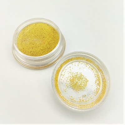 Dois pequenos frascos transparentes com pérolas douradas minúsculas