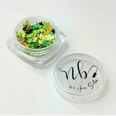 Frasco pequeno com purpurina em forma de folhas verdes e douradas e tampa com texto nb BY Ana Silva