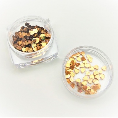 Frasco transparente com pequenos corações metálicos dourados e tampa separada