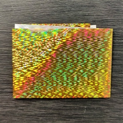 Papel holográfico dourado com padrão refletivo multicolorido